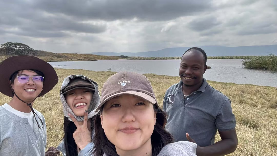 Guests and their guide taking a selfie beside a lake below an escarpment