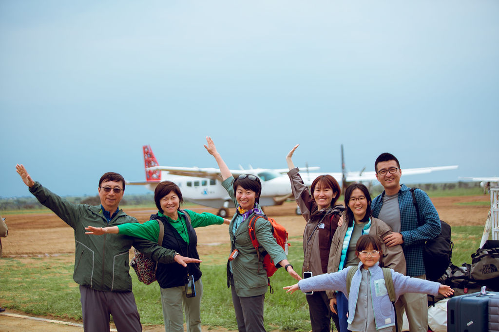 Guests celebrating beside a light aircraft at a bush airstrip