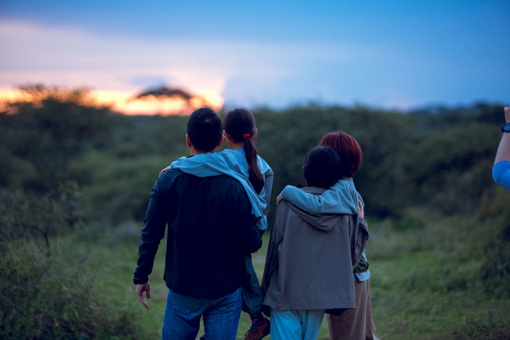 Guests standing together watching the sun set over the bush