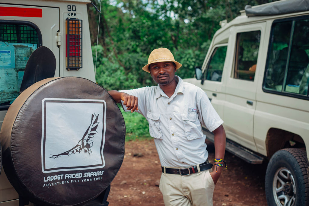 Lappet Faced Safaris guide beside the branded spare wheel cover on his vehicle