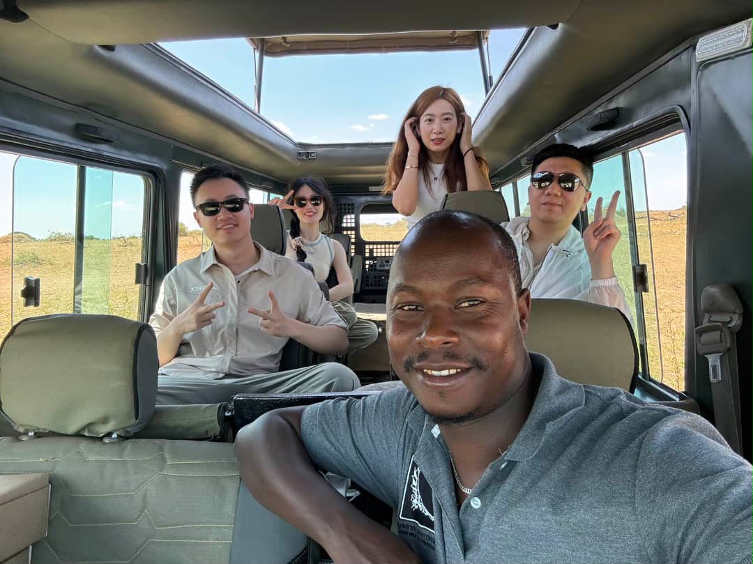 Guide taking a selfie with guests inside the safari vehicle