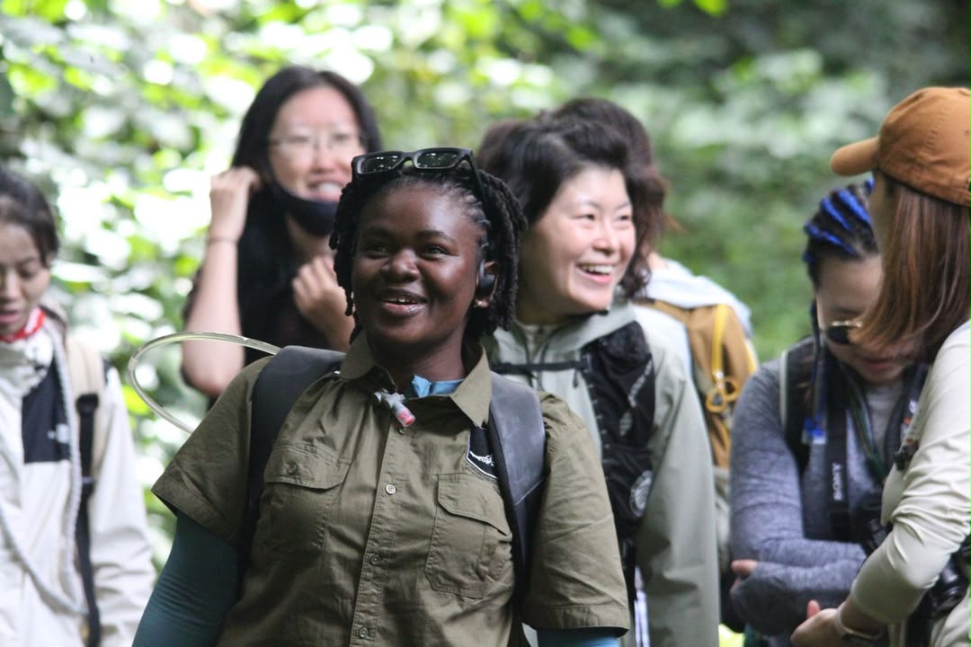 Safari guide smiling with guests around her on a walk