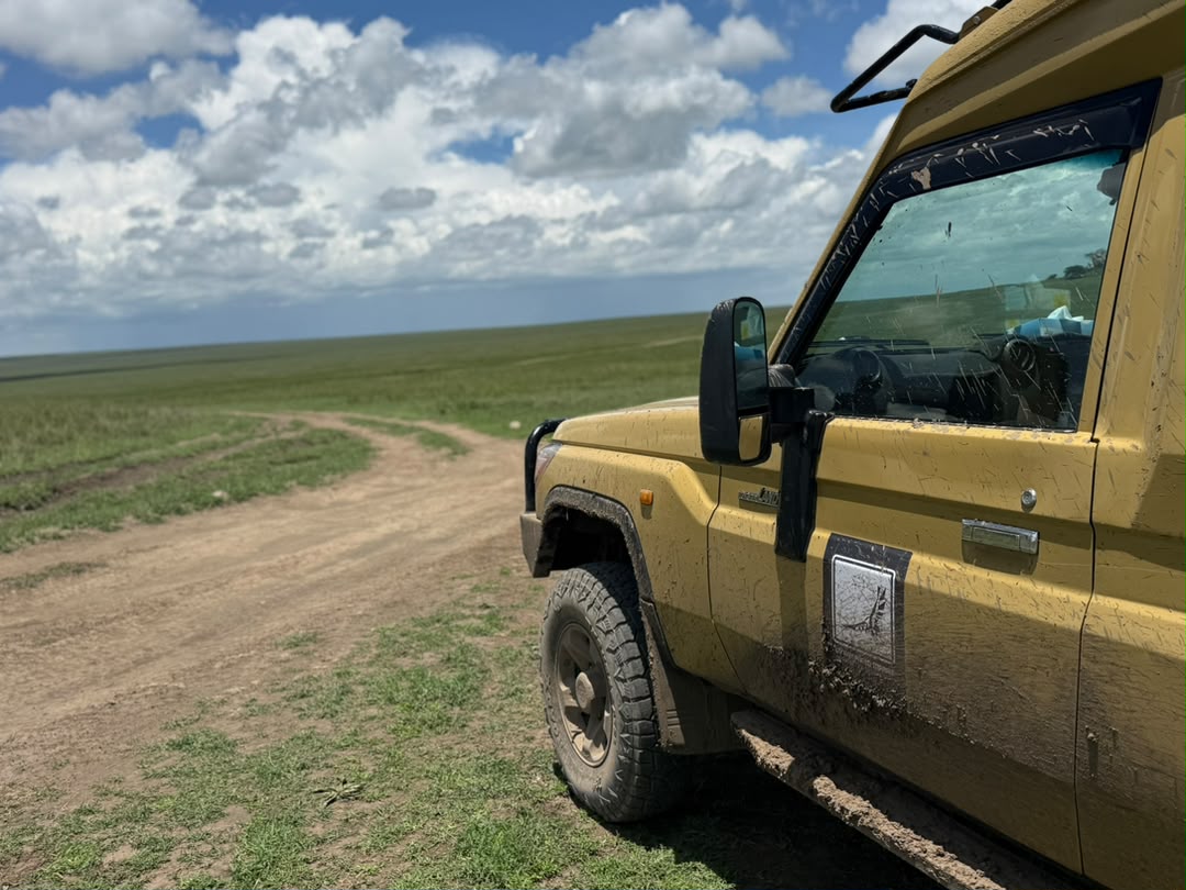 Mud-splashed safari Land Cruiser on a rough track