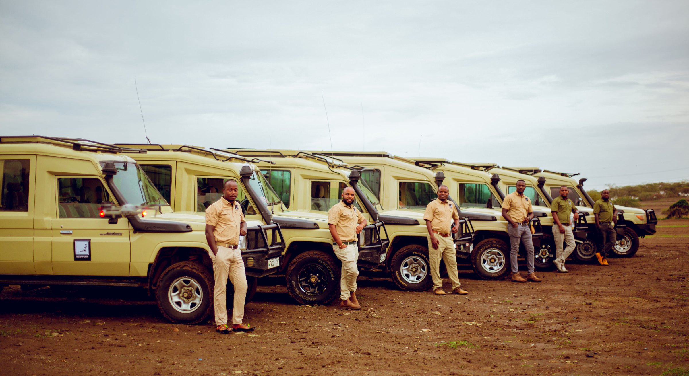 The Lappet Faced Safaris fleet and guiding team lined up alongside their Land Cruisers