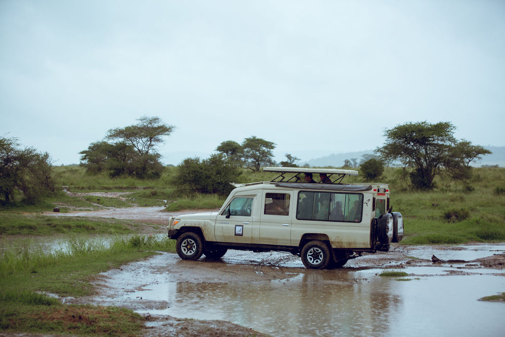 Safari vehicle crossing a flooded stretch of track