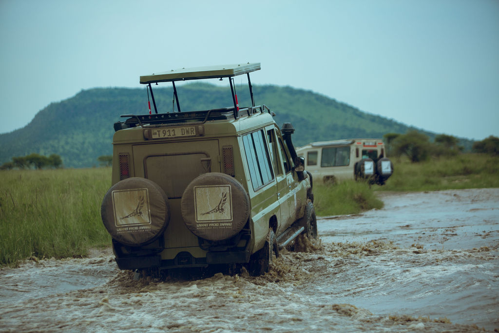 Lappet Faced Safaris vehicle fording a fast, flooded river crossing